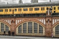 Yellow train on Oberbaum bridge and people walking on the street in city Berlin, Germany Royalty Free Stock Photo