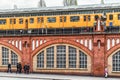 Yellow train on Oberbaum bridge and people walking on the street in city Berlin, Germany Royalty Free Stock Photo