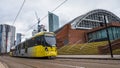 Yellow tram passing the Manchester Central Convention Complex