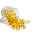 Yellow translucent pills in a glass Cup on a white background. Isolate. Omega, vitamins