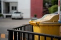 Yellow trash can on a city background