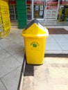 Yellow trash can with green leaf writing placed on the supermarket page