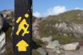 Yellow trekking sign on a wooden pole