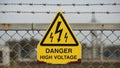 Yellow triangular warning sign reading DANGER HIGH VOLTAGE is attached to a Royalty Free Stock Photo