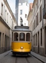 a yellow trolley car is driving down a street.