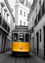 a yellow trolley car is driving down a street.