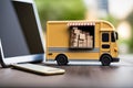 Yellow truck with boxes and tablet on a wooden table in the office