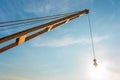 Yellow truck crane boom with hooks and scale weight above blue s Royalty Free Stock Photo