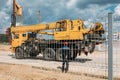 Yellow truck crane and builder behind a mesh fence at a construction site Royalty Free Stock Photo