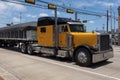 Yellow truck in a highway crossing a small american town Royalty Free Stock Photo