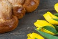 Yellow tuips and Easter bread on grey wooden board. Royalty Free Stock Photo
