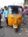 A yellow tuk tuk mini taxi cab