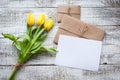 Yellow tulip bouquet and blank greeting card. Top view over wooden table Royalty Free Stock Photo