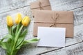 Yellow tulip bouquet and blank greeting card. Top view over wooden table Royalty Free Stock Photo