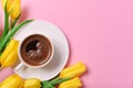 Yellow tulips, a cup of black coffee on a pink background, a place for the inscription Royalty Free Stock Photo