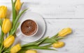 Yellow tulips, a cup of black coffee on a white wooden background, gift, flowers, top view Royalty Free Stock Photo