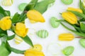 Yellow tulips and easter eggs on white wooden table, top view Royalty Free Stock Photo