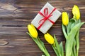 Yellow tulips, gift box on wooden background Royalty Free Stock Photo