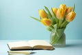 Yellow tulips and a light blue background with a notepad, in the style of understated elegance Royalty Free Stock Photo