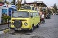 The yellow ultimate Volkswagen camper and half of a classic Volkswagen beetle on top as a moonroof combination Royalty Free Stock Photo