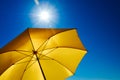 Yellow Umbrella with Bright Sun and Blue Sky Royalty Free Stock Photo