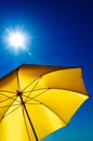 Yellow Umbrella with Bright Sun and Blue Sky Royalty Free Stock Photo