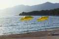 Yellow umbrellas for relax and comfort on idyllic sea beach. Happy summer vacations and tourism concept. Paid service on