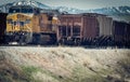 A Yellow Union Pacific Diesel Locomotive Engine And Grain Hopper Cars