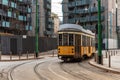 Yellow urban tram runs along the city tracks