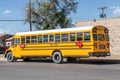 Yellow USA full-sized Schoolbus parked on street of small town Royalty Free Stock Photo