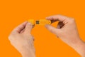 Yellow USB flash memory on hand with isolated orange background Royalty Free Stock Photo