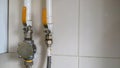 Yellow valves and natural gas pipes in a modern home boiler room in a kitchen with ceramic tiles. Gas valve ball valve, gas and
