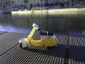 Yellow vespa like model parked in front of the Darsena in Milan Italy Royalty Free Stock Photo