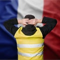 Yellow vests protests in France. A young man stands with his back and holds his hands on his head as a sign of obedience. Royalty Free Stock Photo
