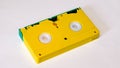 Yellow vhs video cassette with green curtain on white background, back side Royalty Free Stock Photo