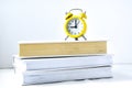 Yellow vintage alarm clock with book on white background, Back to school, Time to learn, wealth knowledge