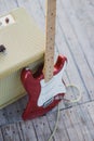 Yellow vintage guitar aplifier with cable and red electric guitar Royalty Free Stock Photo