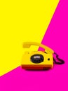 Retro vintage phone handset yellow pink red purple plastic orange disko background old style shadow 90 answer reply raised Royalty Free Stock Photo