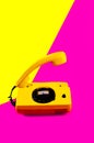 Retro vintage phone handset yellow pink red purple plastic orange disko background old style shadow 90 answer reply raised Royalty Free Stock Photo