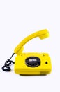 Retro vintage phone handset yellow plastic white disko background old style 90 telephone answer call raised Royalty Free Stock Photo