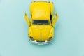 Yellow vintage retro toy car isolated on blue pastel colorful background Royalty Free Stock Photo