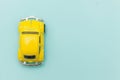 Yellow vintage retro toy car isolated on blue pastel colorful background Royalty Free Stock Photo