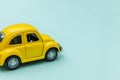 Yellow vintage retro toy car isolated on blue pastel colorful background Royalty Free Stock Photo