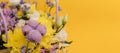 Yellow-violet flower arrangement in a box of chrysanthemums, eustomas, cotton inflorescences and dried flowers on a yellow Royalty Free Stock Photo