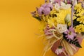 Yellow-violet flower arrangement in a box of chrysanthemums, eustomas, cotton inflorescences and dried flowers on a yellow Royalty Free Stock Photo