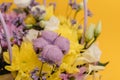 Yellow-violet flower arrangement in a box of chrysanthemums, eustomas, cotton inflorescences and dried flowers on a yellow Royalty Free Stock Photo