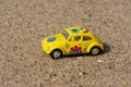 Yellow Volkswagen beetle made from metal on the beach. Royalty Free Stock Photo