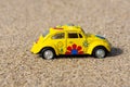 Yellow Volkswagen beetle made from metal on the beach. Royalty Free Stock Photo