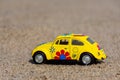 Yellow Volkswagen beetle made from metal on the beach. Royalty Free Stock Photo