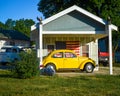 Yellow Volkswagon Bug in front of American Flag